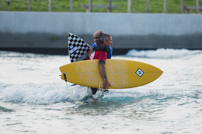 Pegleg hugging a competitor during the English Adaptive Surf Open at The Wave in Bristol