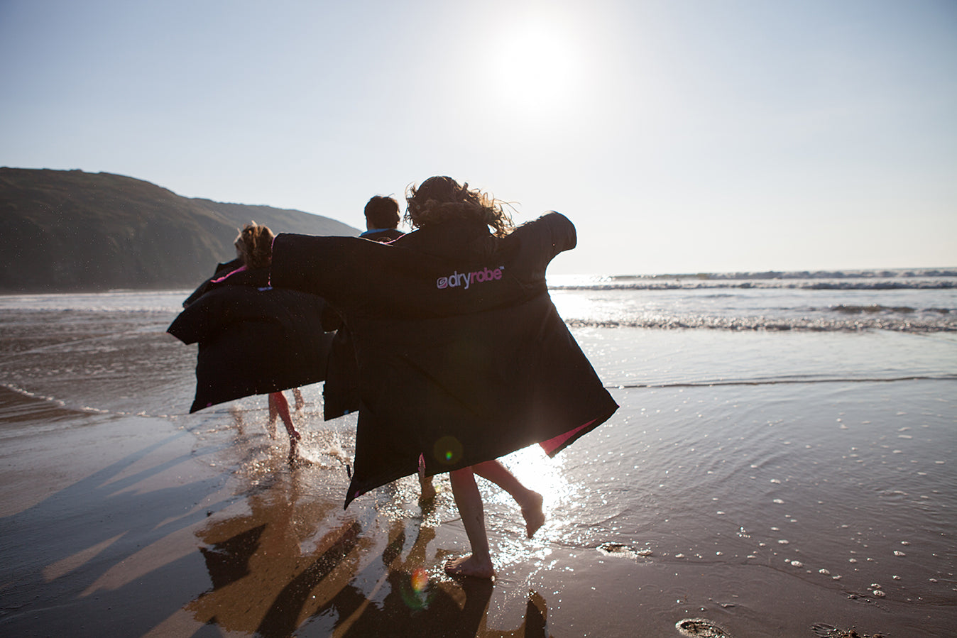 Children playing on the beach in dryrobes