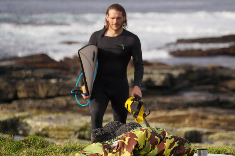 Taz Knight walking out of the water carrying his surfboard