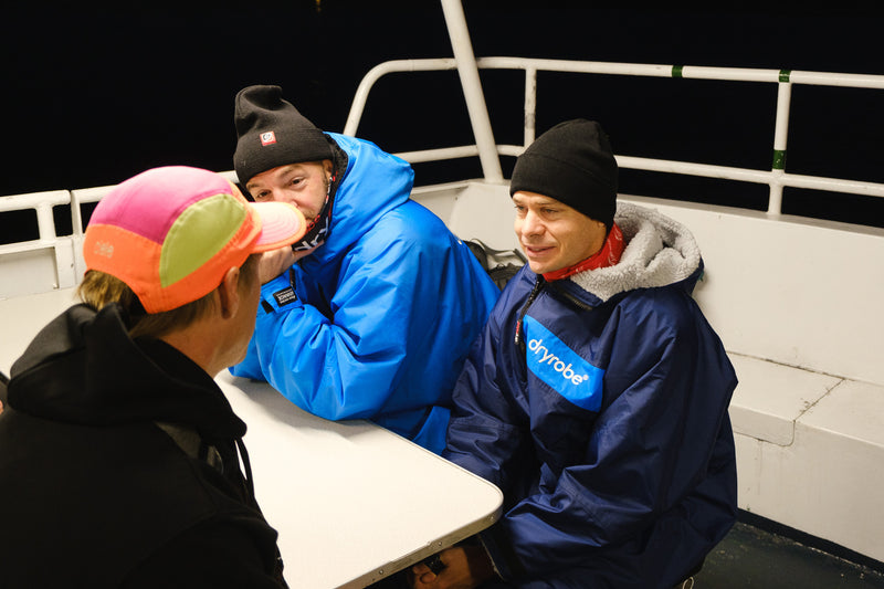 Markus Rössel and Daniel Rowland sat on ferry wearing dryrobe® Advance change robes