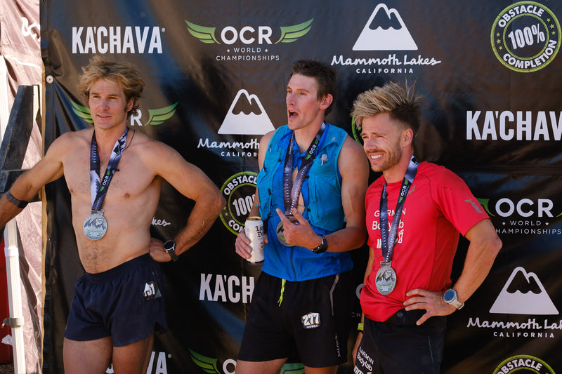 Ryan Atkins, Ian Hoesk and Leon Kofed stood at the finish of the 15k race at OCRWC wearing their medals