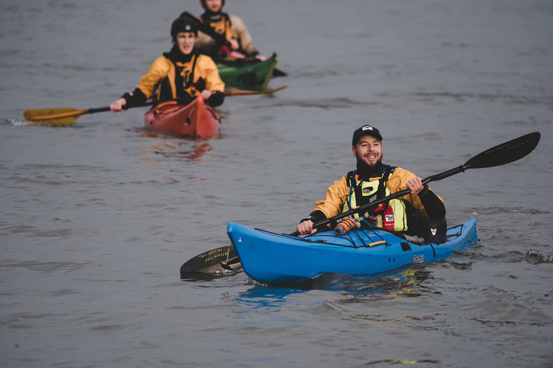 Paddling the Margins team paddling their kayaks at sea 