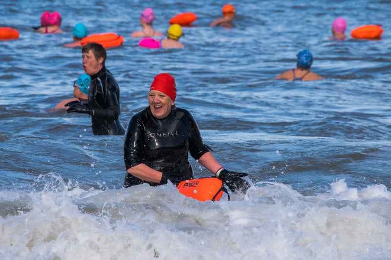 Open water swimmer in the sea in a wetsuit and smiling