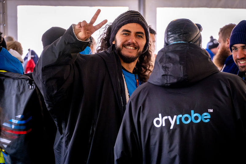 A man doing the peace sign at the camera wearing a dryrobe