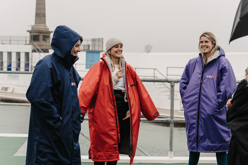 Swimmers smiling before a swim in their dryrobe® change robes