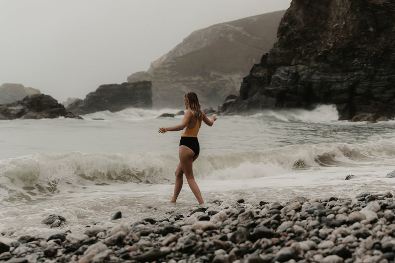 A woman walking into the sea to swim
