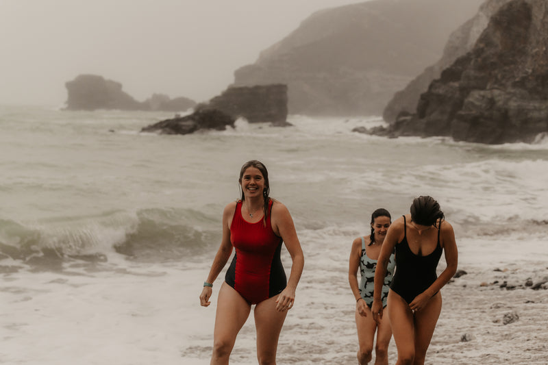 A group of women walking out the water after a sea on the beach