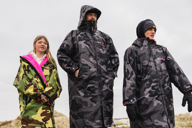 Lila, Ben and Lukas Skinner stood together on beach in dryrobe Advance change robes