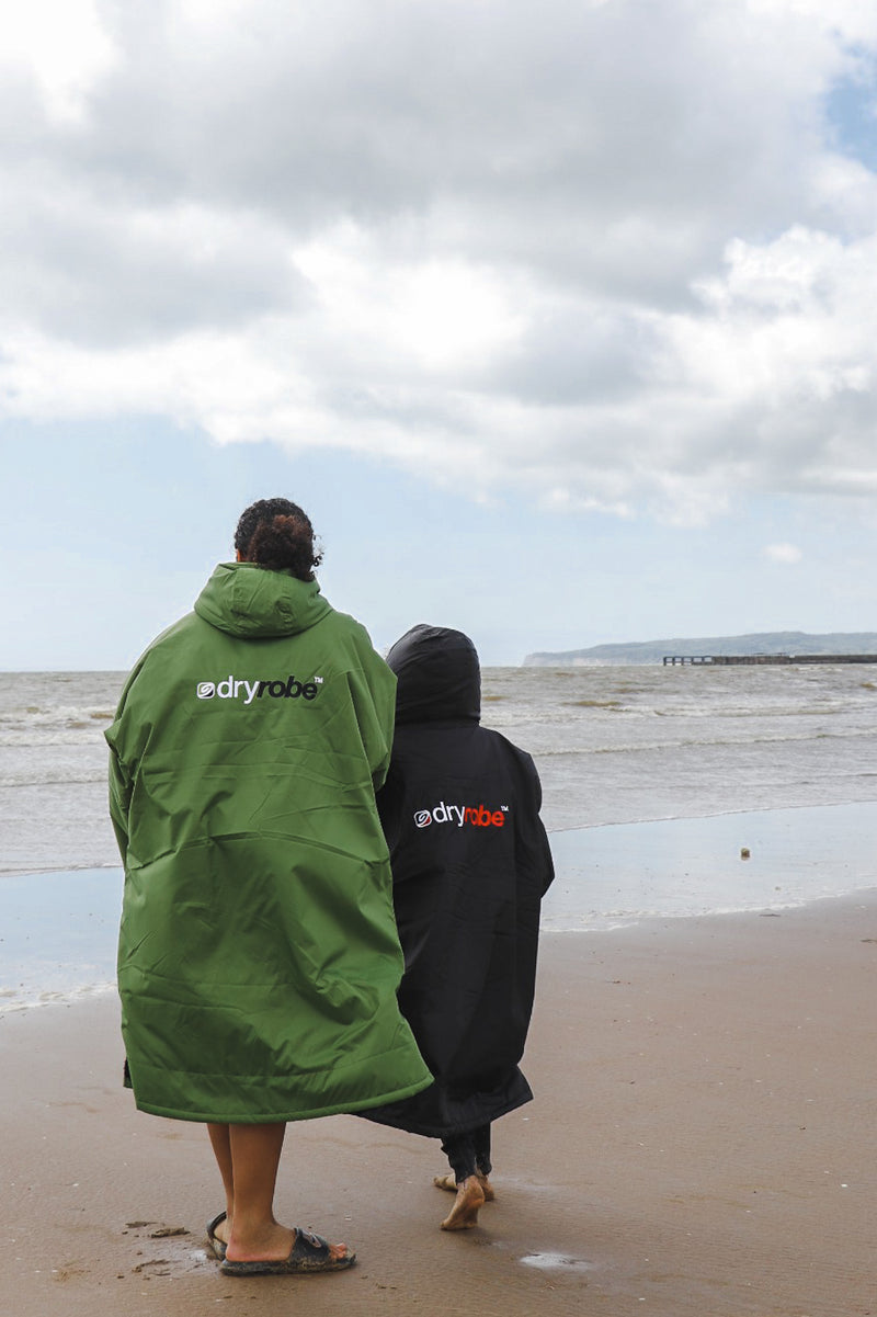 Omie Dale and a child looking out to sea wearing dryrobes