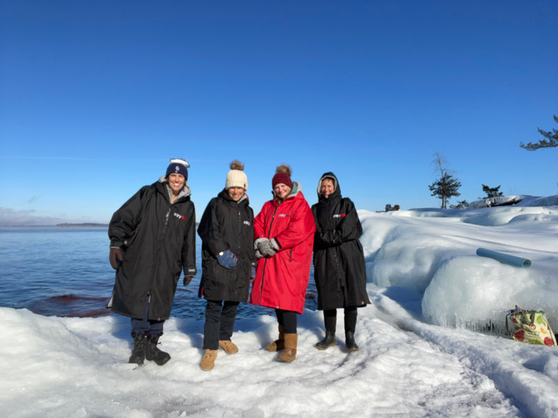 A group of swimmers stood by a snowy Lake Champlain in Vermont wearing dryrobes 