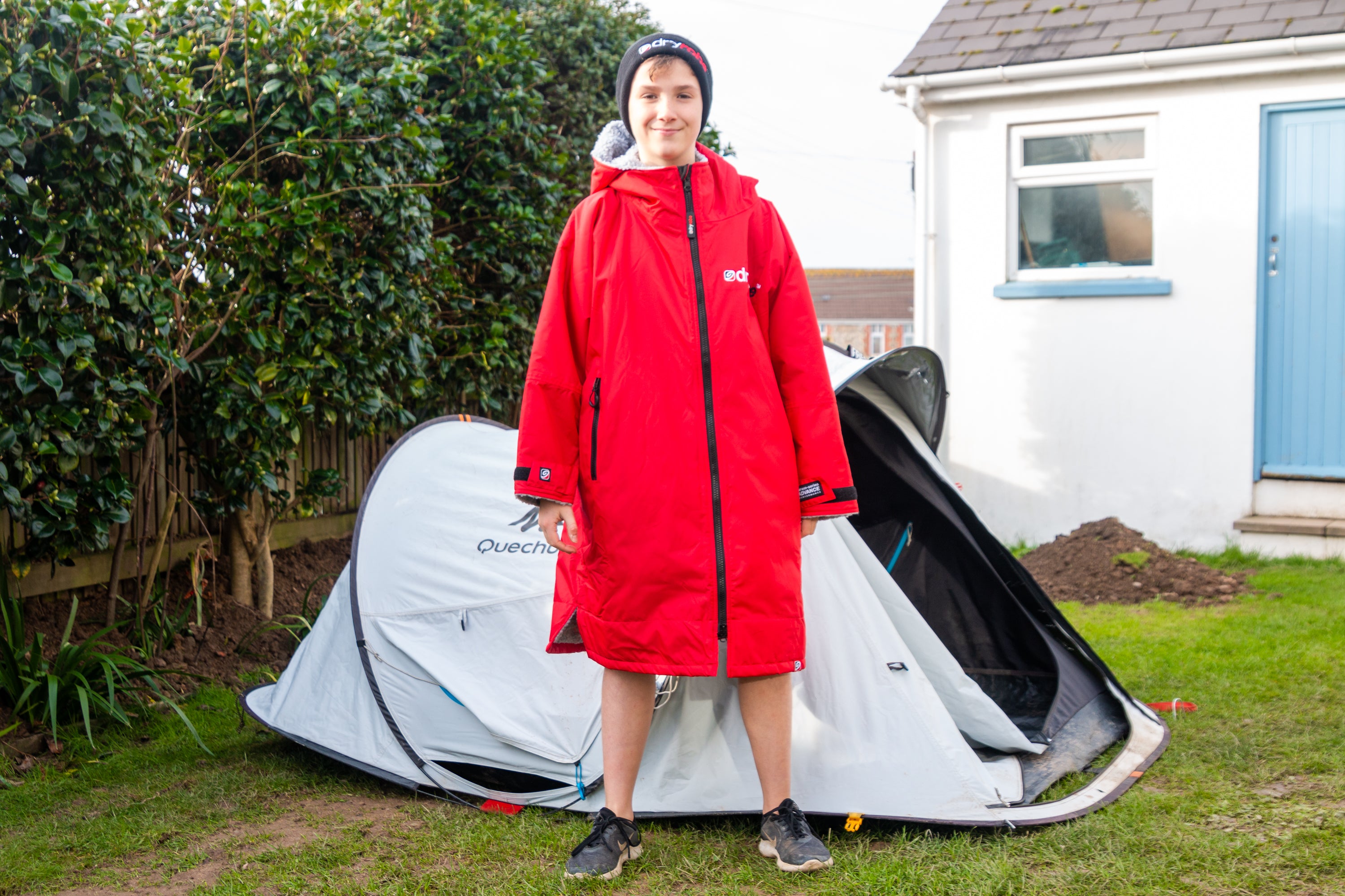 Max Woosey standing by his tent wearing a red dryrobe