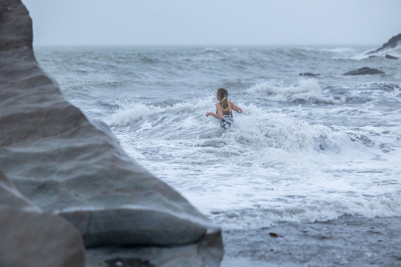 A woman wading into the sea for a swim