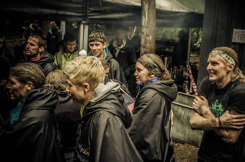 Wet and muddy OCR athletes staying warm in their dryrobe® Advance changes robes after a racees 