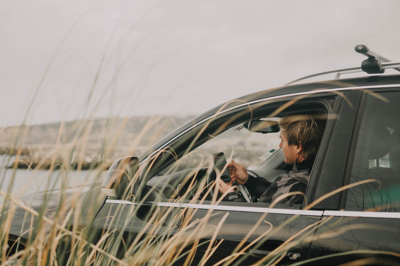 Big wave surfer Andrew Cotton in a car looking at the surf 