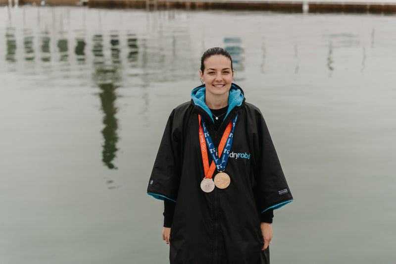 Female swimmer wearing a dryrobe® change robe with Olympic medals around her neck