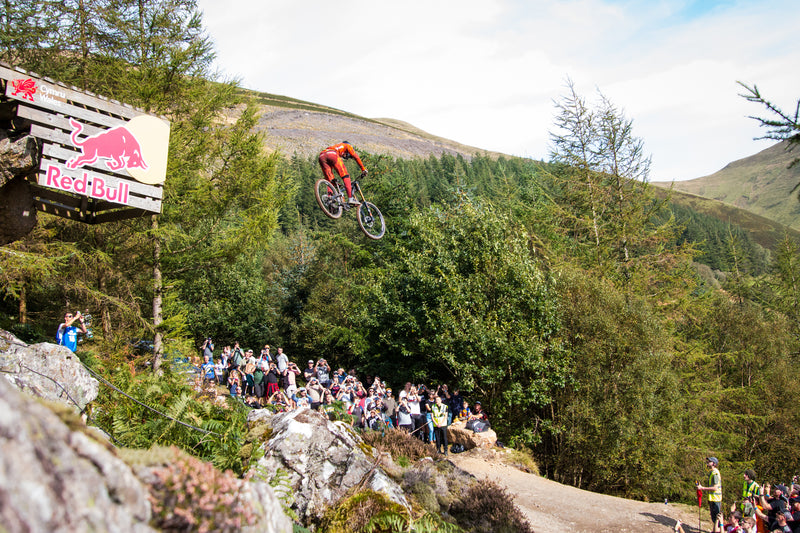 A mountain biker in the air  racing at Red Bull Hardline