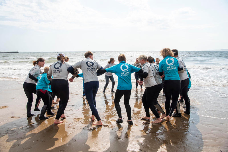 A Wave Project group running into the sea