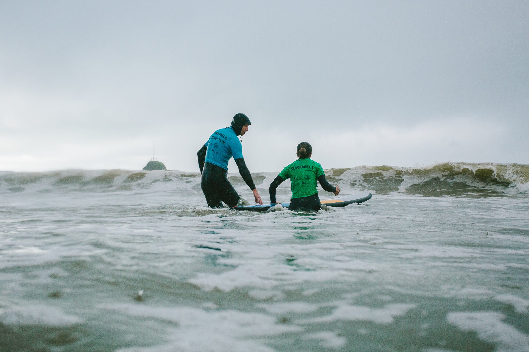 Surf therapy instructor in the water with a Surfwell participant