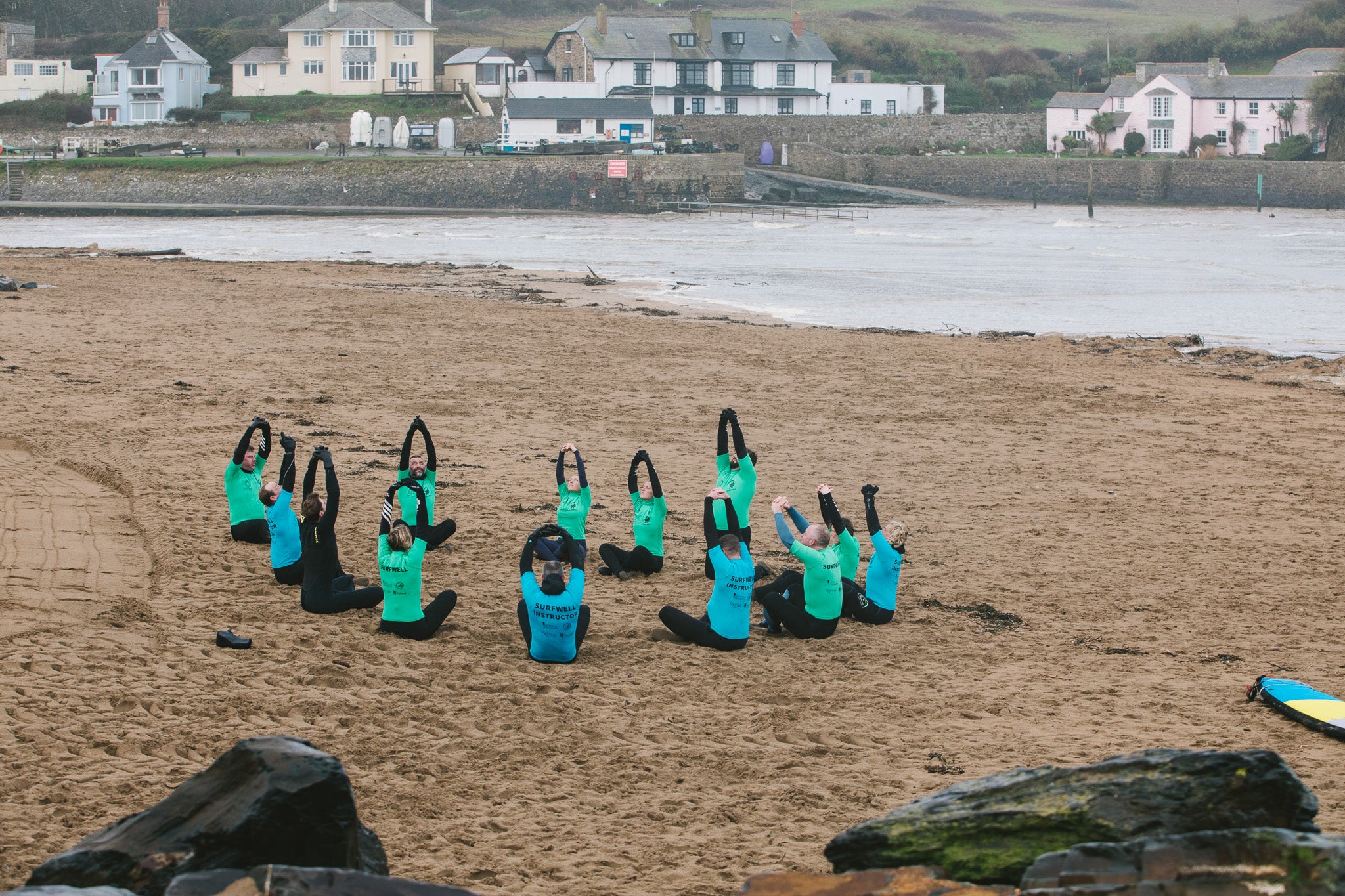 Surfwell surf therapy participants stretching on the beach