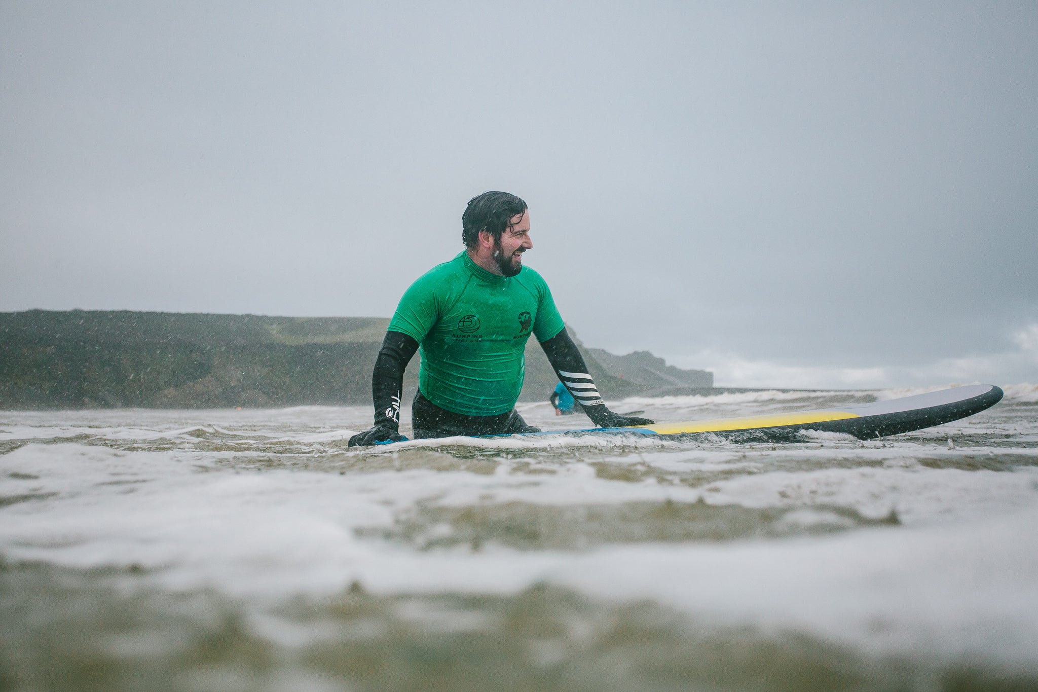 Surf instructor in the water holding a surfboard