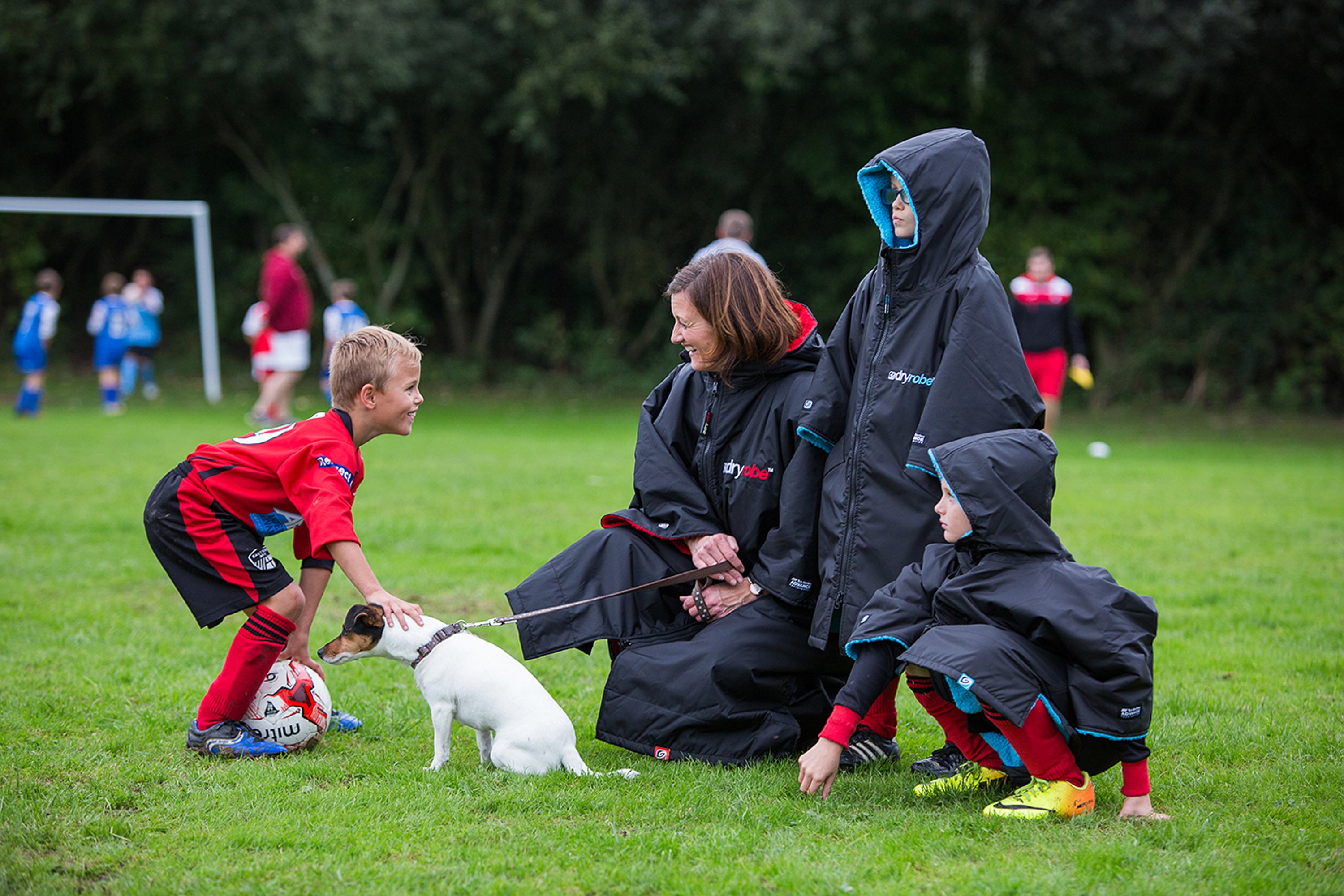 Family watching a football match from the sidelines 