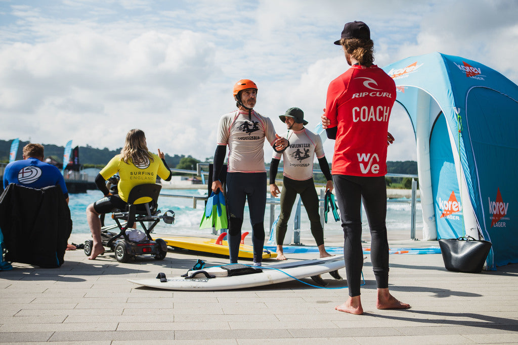 Coaches and Volunteers getting ready to head into the water at the 2021 dryrobe English Adaptive Surfing open at The Wave 