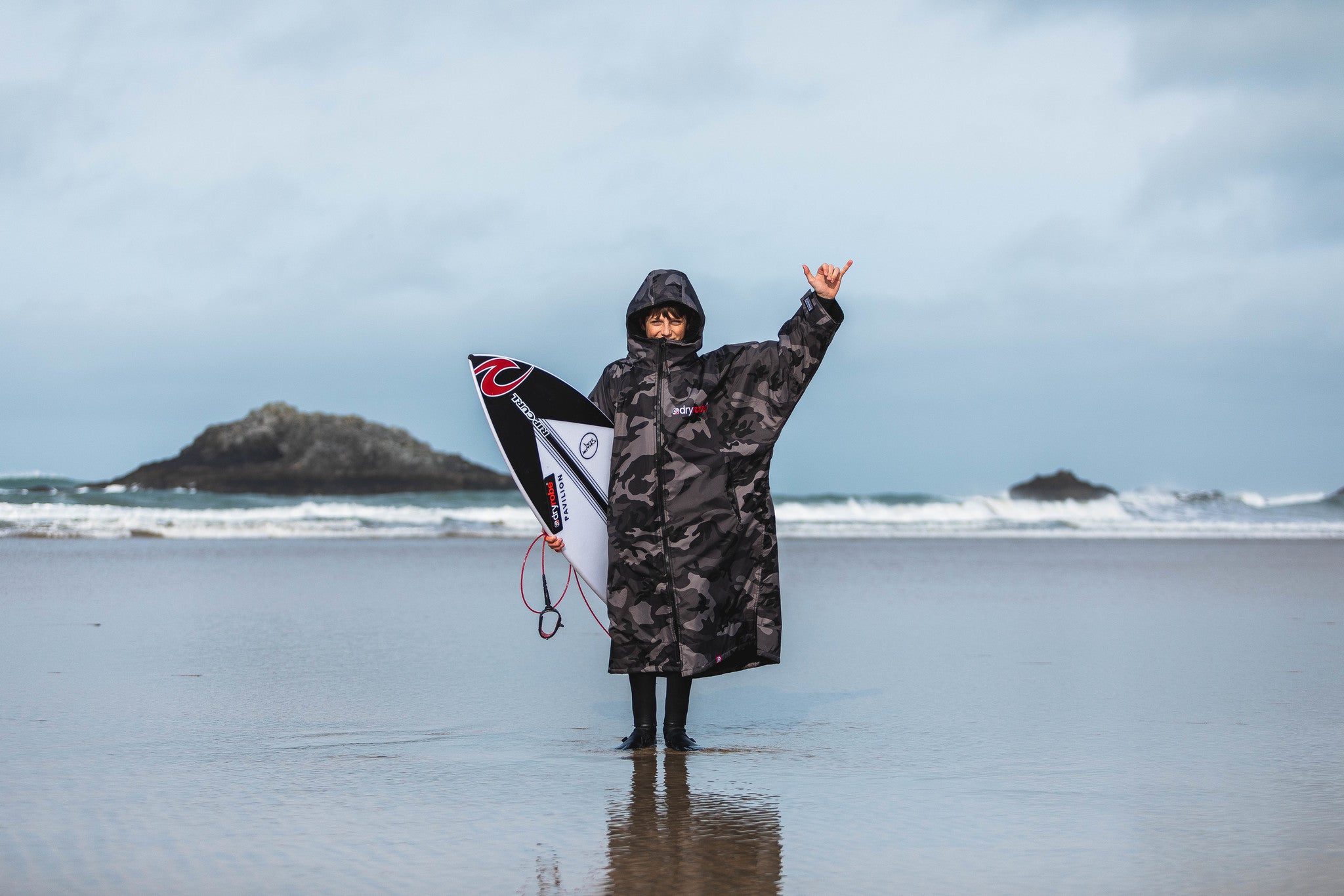 Lukas Skinner on the beach wearing his dryrobe® Advance and throwing a shakka