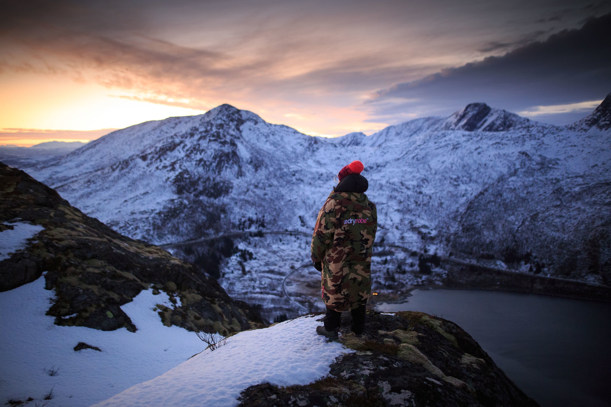 Cal Major standing on a mountain watching the the sunset over a Norwegian fjord