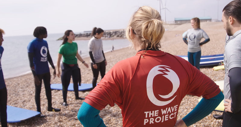 Volunteers and participants stood on the beach at a Wave Project session