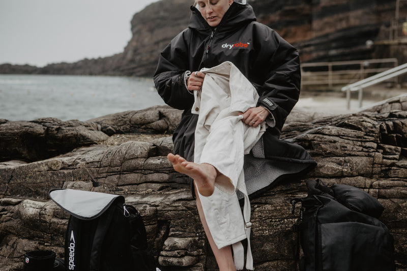 Sophie Hellyer getting changed into jeans on the beach using a dryrobe change robe