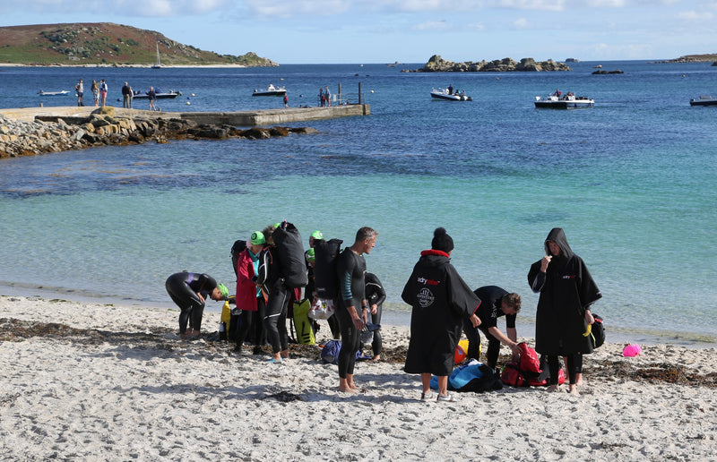 Swimmers getting ready to head into the blue water in the Isles of Scilly 