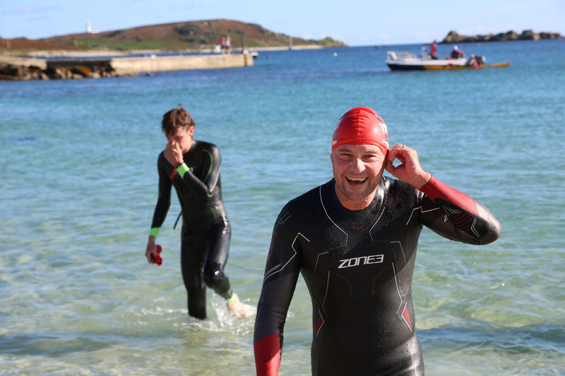 Two swimmers walking out of the ocean 