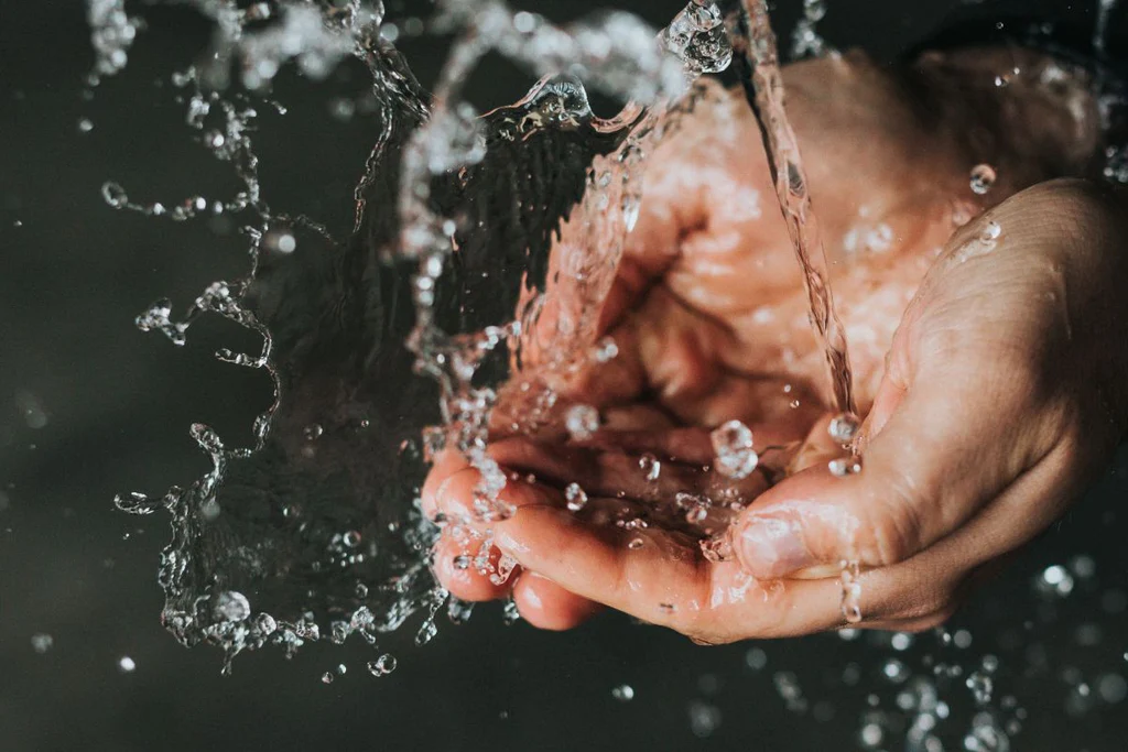 Hands scooping water.