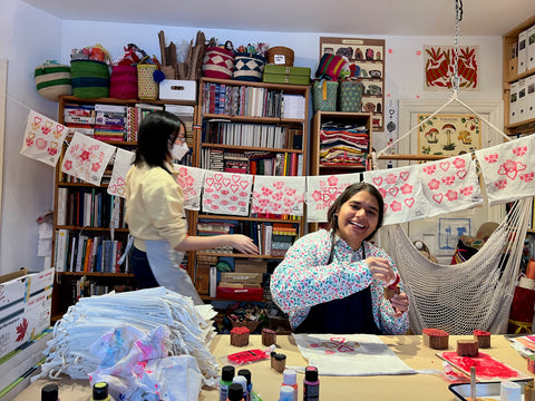 busy, happy art studio with block-printed bags on a line