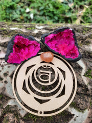 Tree trunk with on top our wooden sacral chakra symbol and pink quartz geode