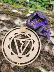 Tree trunk with on top our wooden solar plexus symbol and purple quartz geode