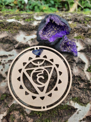 Tree trunk with on top our wooden throat chakra symbol and Purple Quartz Geode