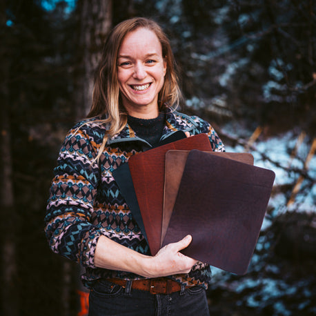 woman holding mouse pads in four different colors