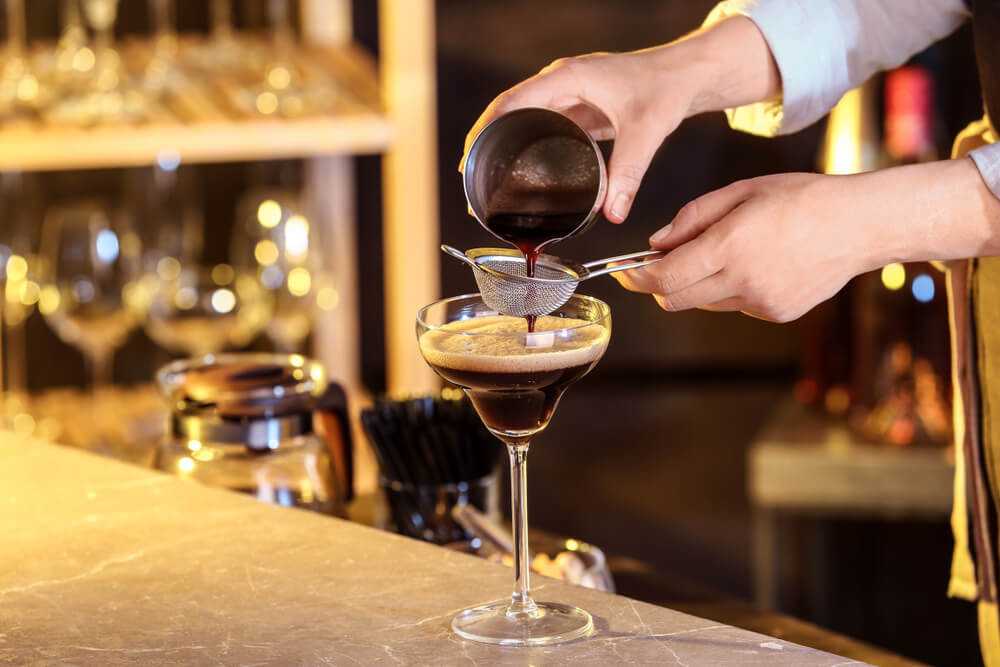 bartender preparing Espresso Martini on bar counter 