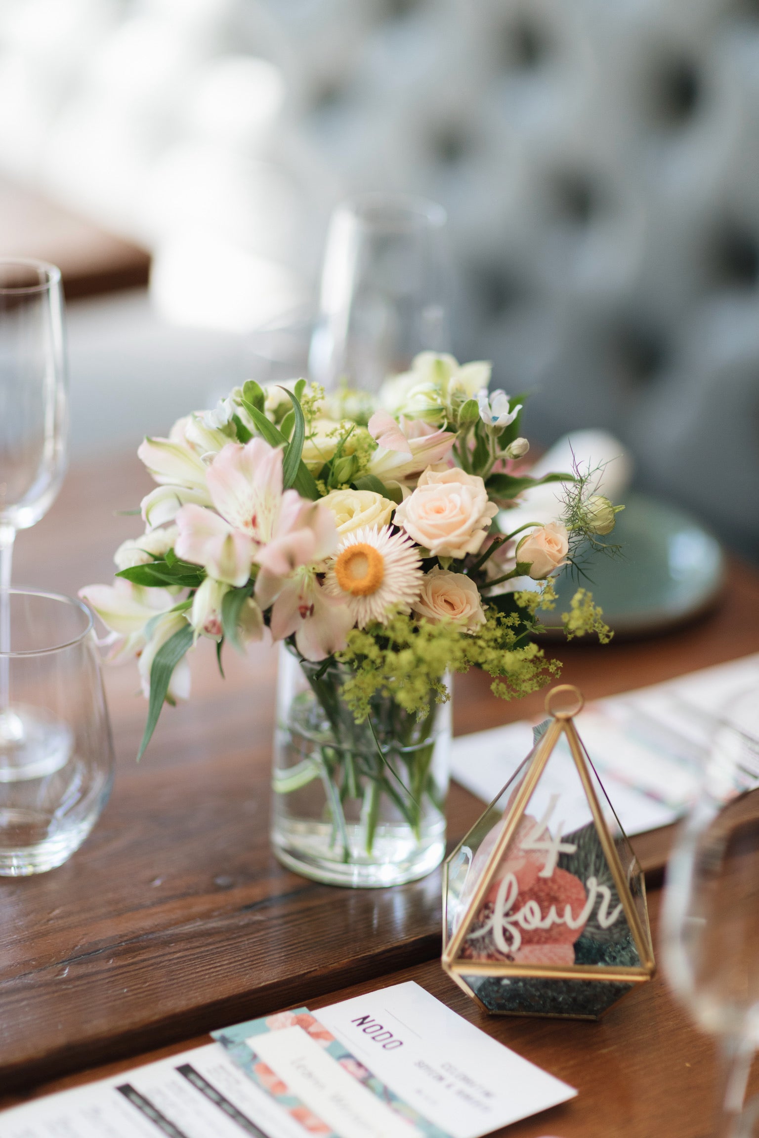 A mini vase arrangement of wedding flowers on a restuarant table in Toronto.