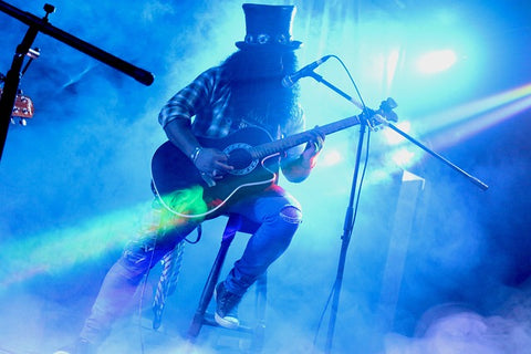 Gitarist met akoestische gitaar op podium (Slash)