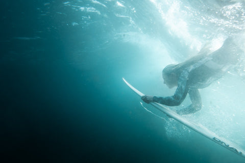 Image of woman with surfboard diving