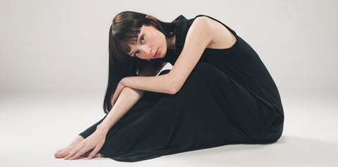 Model in vegan lyocell dress in black.