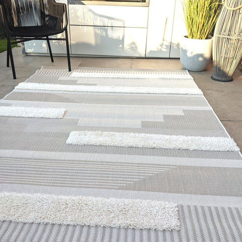 Leon Cream and Grey outdoor rug with abstract designs on a summery patio