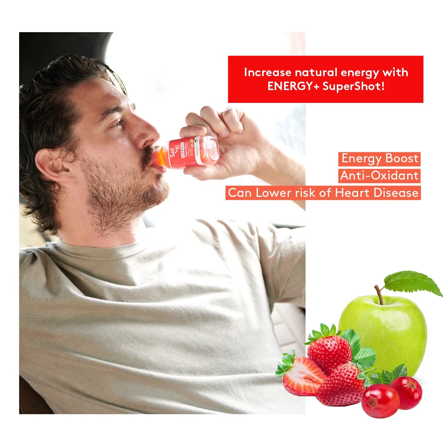 a man drinking a bottle ENERGY+ SuperShot, next to a green apple, strawberries and red coffee beans