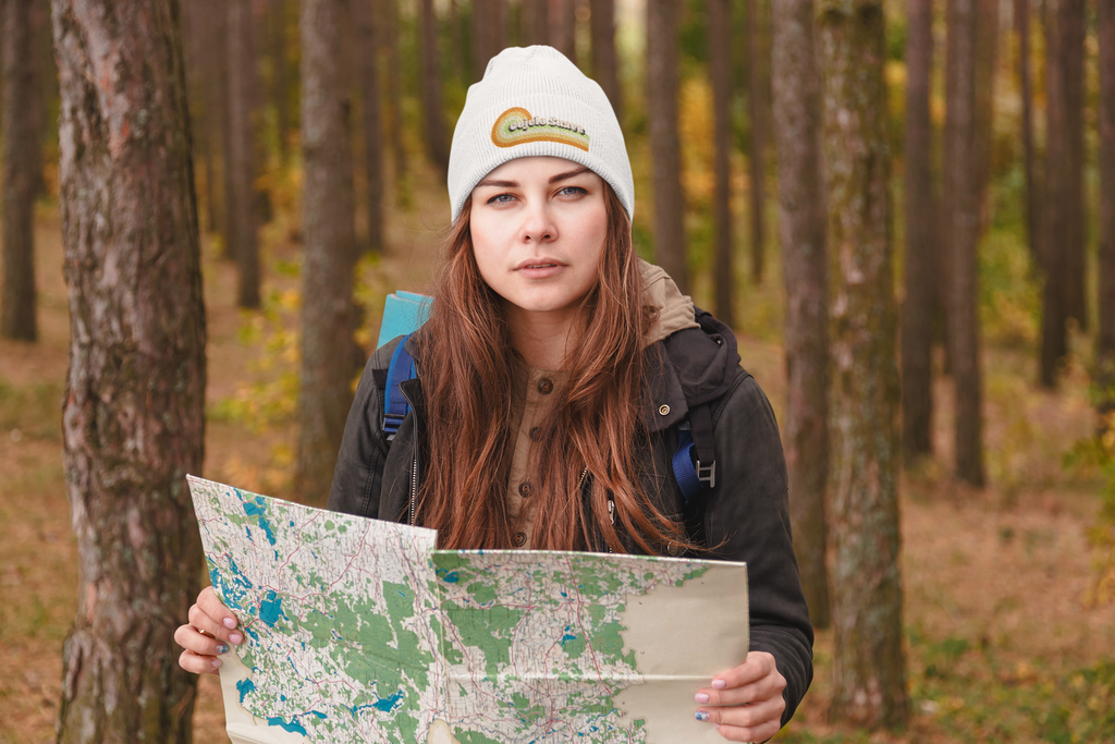 woman wearing a white beanie with the cojelo suave embroidered graphic on it