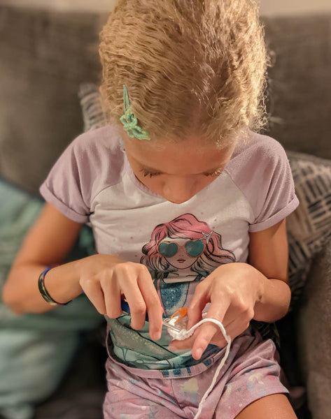 12-year old girl crocheting an amigurumi plushie using The Woobles' white Easy Peasy yarn