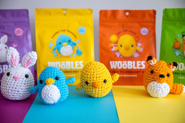 Bunny, penguin, chick and fox crochet kits with The Woobles crochet kit packaging at the back