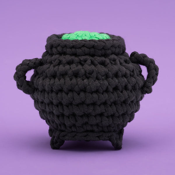 Tiny black cauldron with green potion