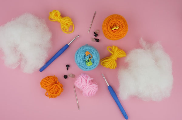 Materials needed to crochet amigurumi like crochet hooks, safety eyes, yarn and stuffing